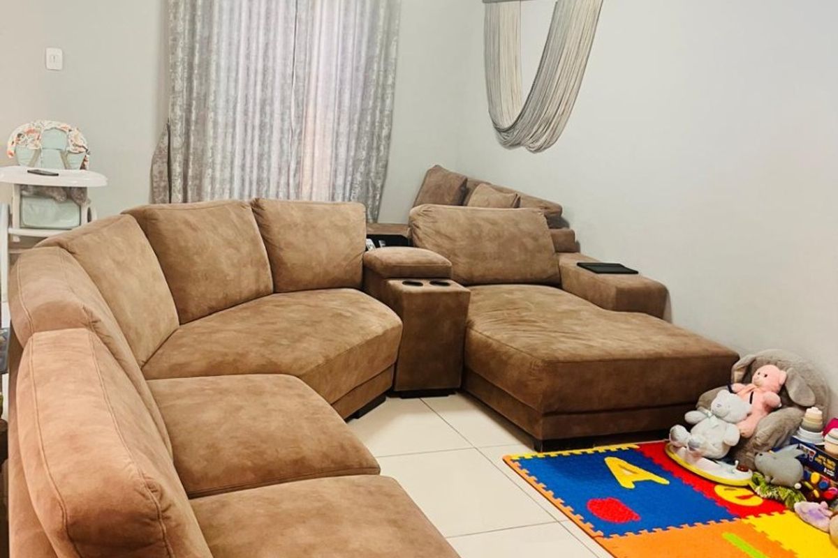 A comfortable living room featuring large format floor tiles and neutral wall finishes, providing a functional space for relaxation.