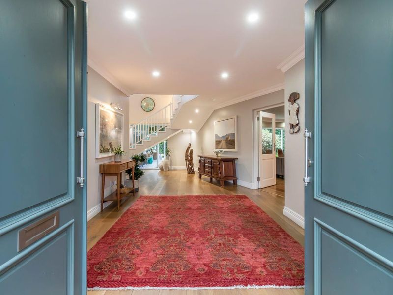 Welcoming entrance hall featuring hardwood flooring, recessed lighting, and an elegant staircase leading to the upper level.