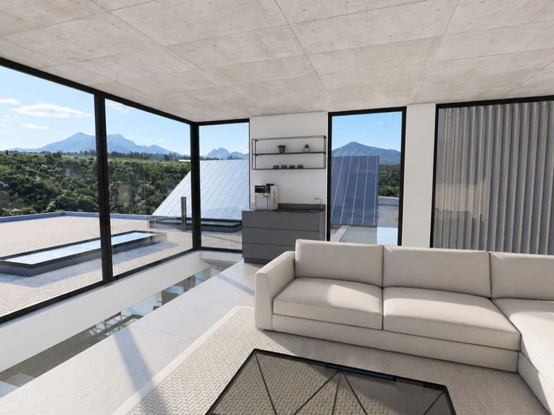 Modern living area featuring floor-to-ceiling windows with expansive mountain views, exposed concrete ceilings, and sleek tiled flooring.