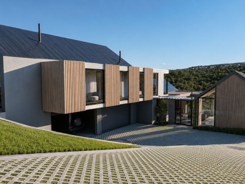 Modern architectural house featuring a striking combination of metal roofing, timber slat cladding, and expansive glass windows with a paved driveway.