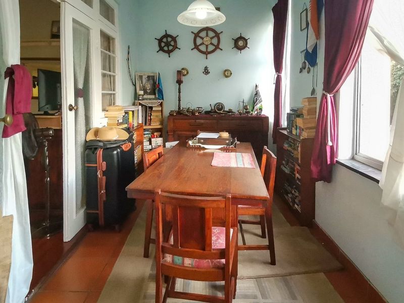 A dining room featuring tiled flooring, pendant lighting, and access through classic french doors, offering a functional space for meals.