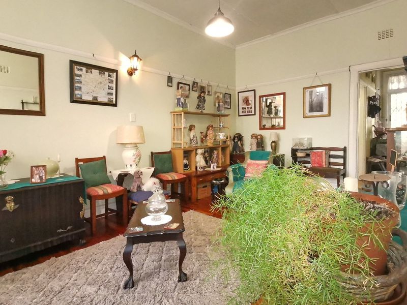 A living room featuring original hardwood flooring, coved ceilings, and classic picture rails, offering a traditional foundation for modern updates.