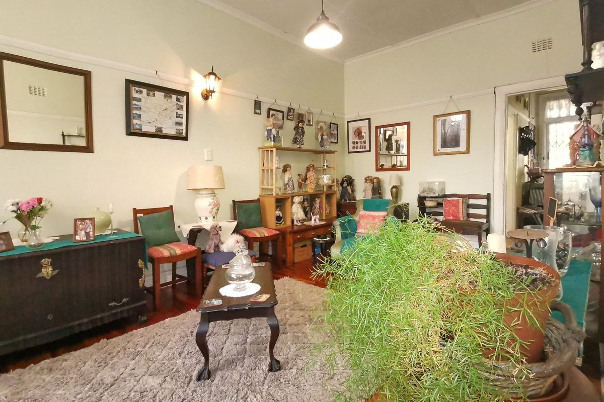 A living room featuring original hardwood flooring, coved ceilings, and classic picture rails, offering a traditional foundation for modern updates.