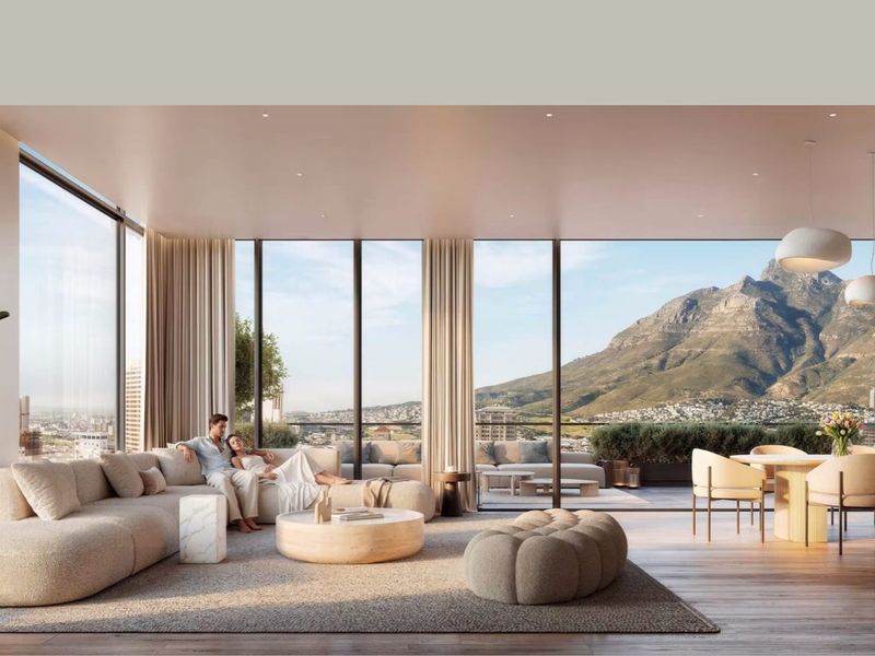 Spacious open-plan living area featuring floor-to-ceiling glass windows, hardwood flooring, and seamless access to a private balcony with mountain views.