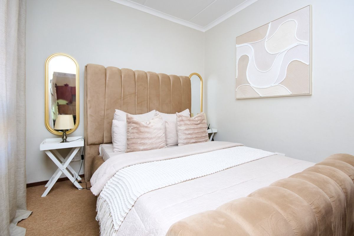 A well-maintained bedroom featuring neutral wall finishes and carpeted flooring.