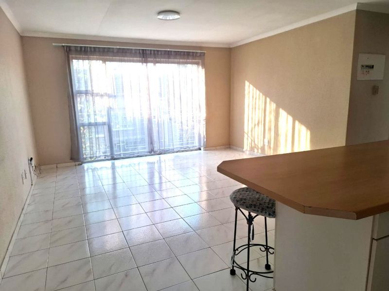 Open plan living area featuring tiled flooring and a large sliding glass door providing access to the exterior.