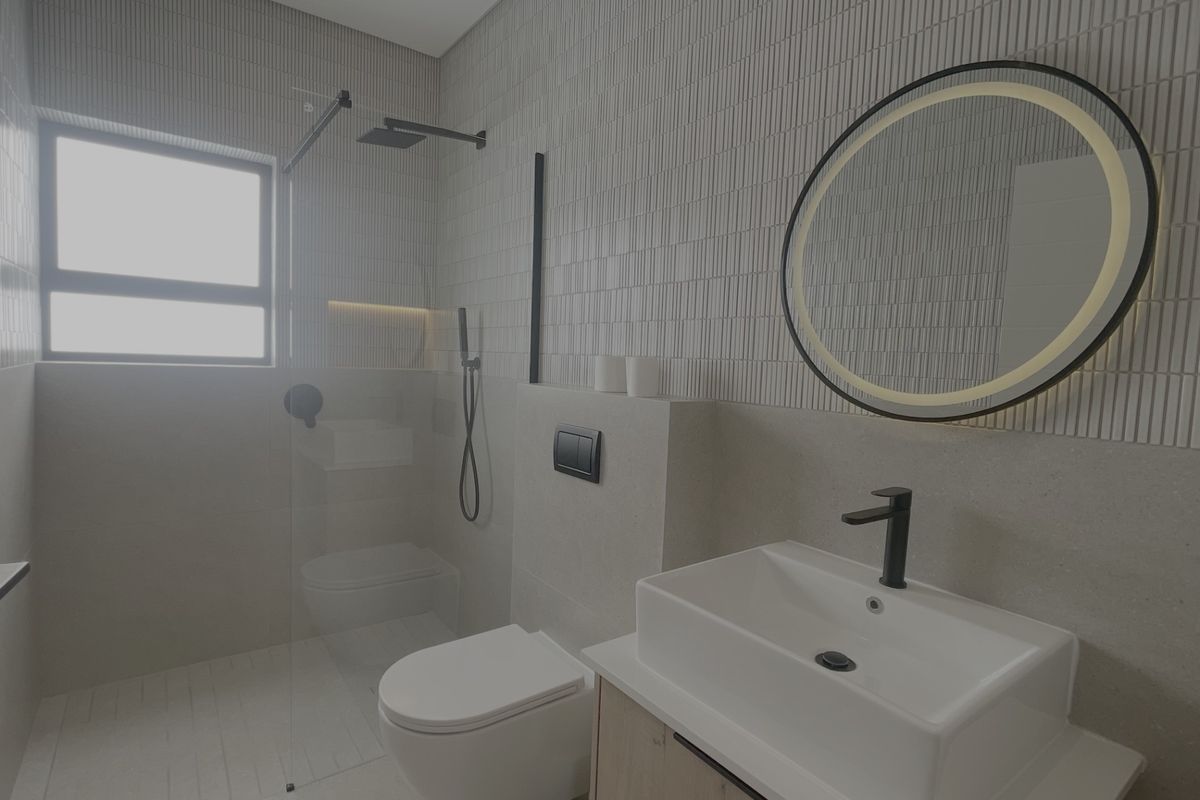 Modern bathroom featuring a wall-mounted toilet, glass-enclosed shower with rain head, vessel sink vanity, and stylish textured wall tiling.
