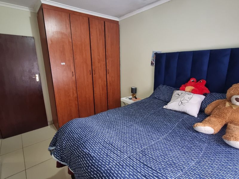 A bedroom featuring built-in wooden cabinetry and tiled flooring, providing functional storage space within the apartment.