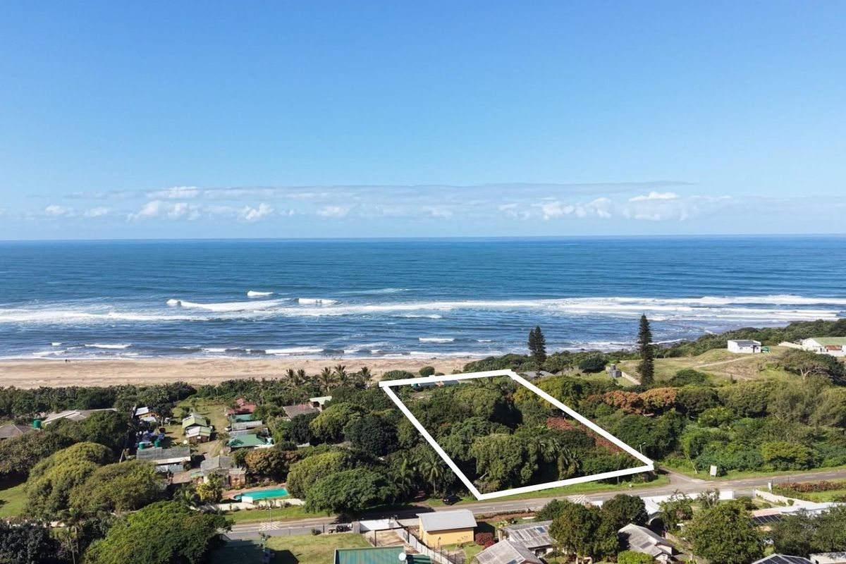 Aerial view of a coastal property plot highlighted in white, showcasing its prime location near the ocean and surrounding natural landscape.