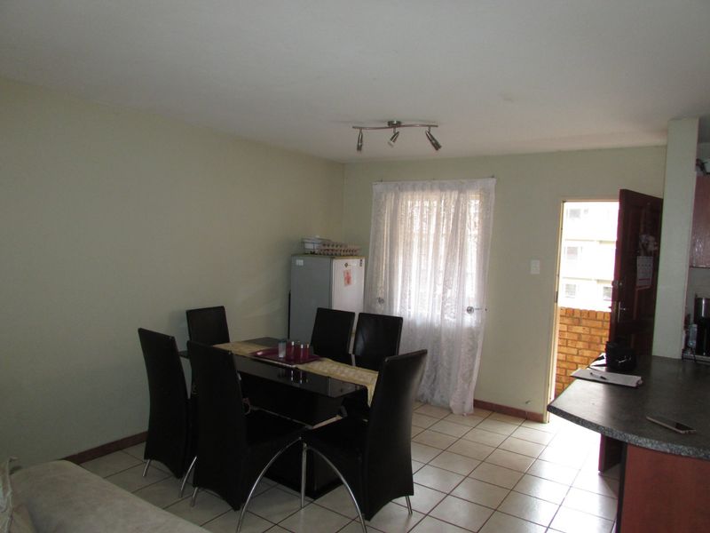 Open plan living and dining area featuring tiled flooring and direct access to an outdoor balcony space.