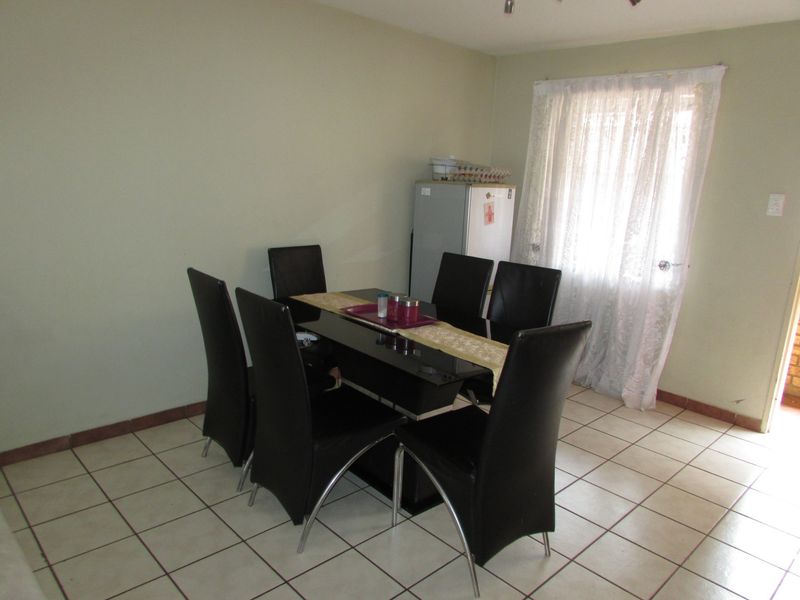 A functional dining area featuring tiled flooring and natural light from a window, providing a practical space for meals.