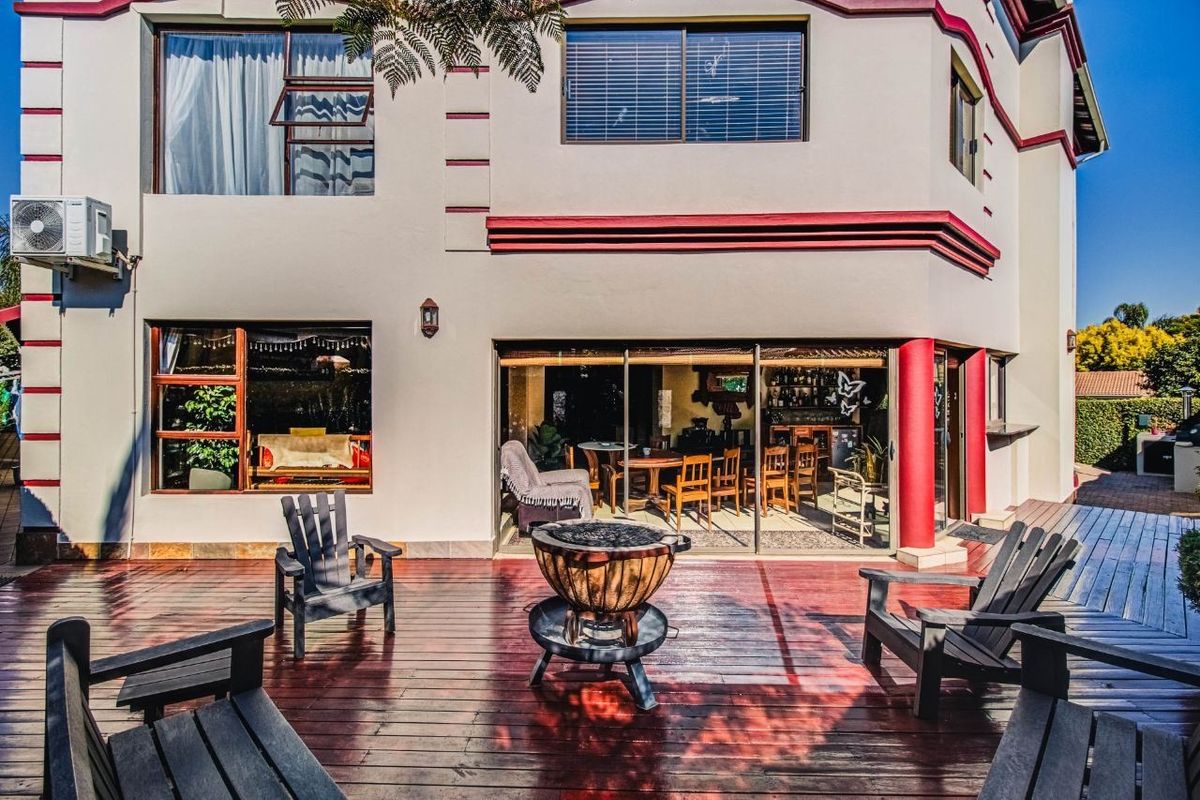A spacious rear patio featuring timber decking, sliding glass doors leading to the interior, and an integrated air conditioning unit on the exterior wall.