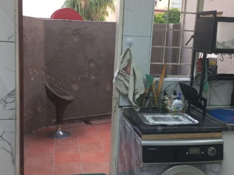 Laundry area featuring marble-effect wall tiles and direct access to a small exterior courtyard space.