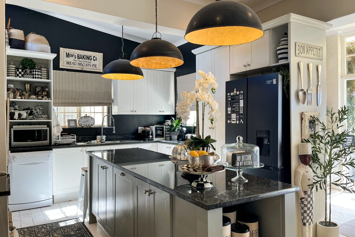 A well-appointed kitchen featuring a central island with granite countertops, shaker-style cabinetry, and stylish pendant lighting, creating a functional and inviting culinary space.