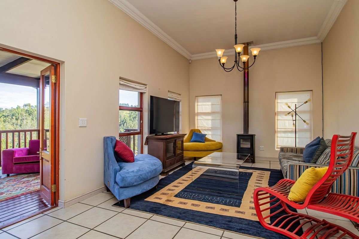 Spacious living room featuring a built-in wood-burning fireplace, tiled flooring, and direct access to an outdoor balcony with scenic views.