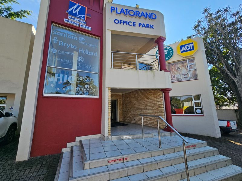 Front entrance of Platorand Office Park featuring tiled steps, stainless steel handrails, and prominent corporate signage on a multi-level commercial building facade.