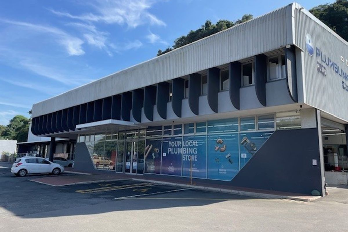 Commercial office and retail building featuring a modern facade, large glass storefront windows, and dedicated parking area.