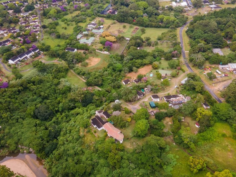 An aerial view of the commercial property grounds, showcasing the surrounding landscape, access roads, and proximity to the river.