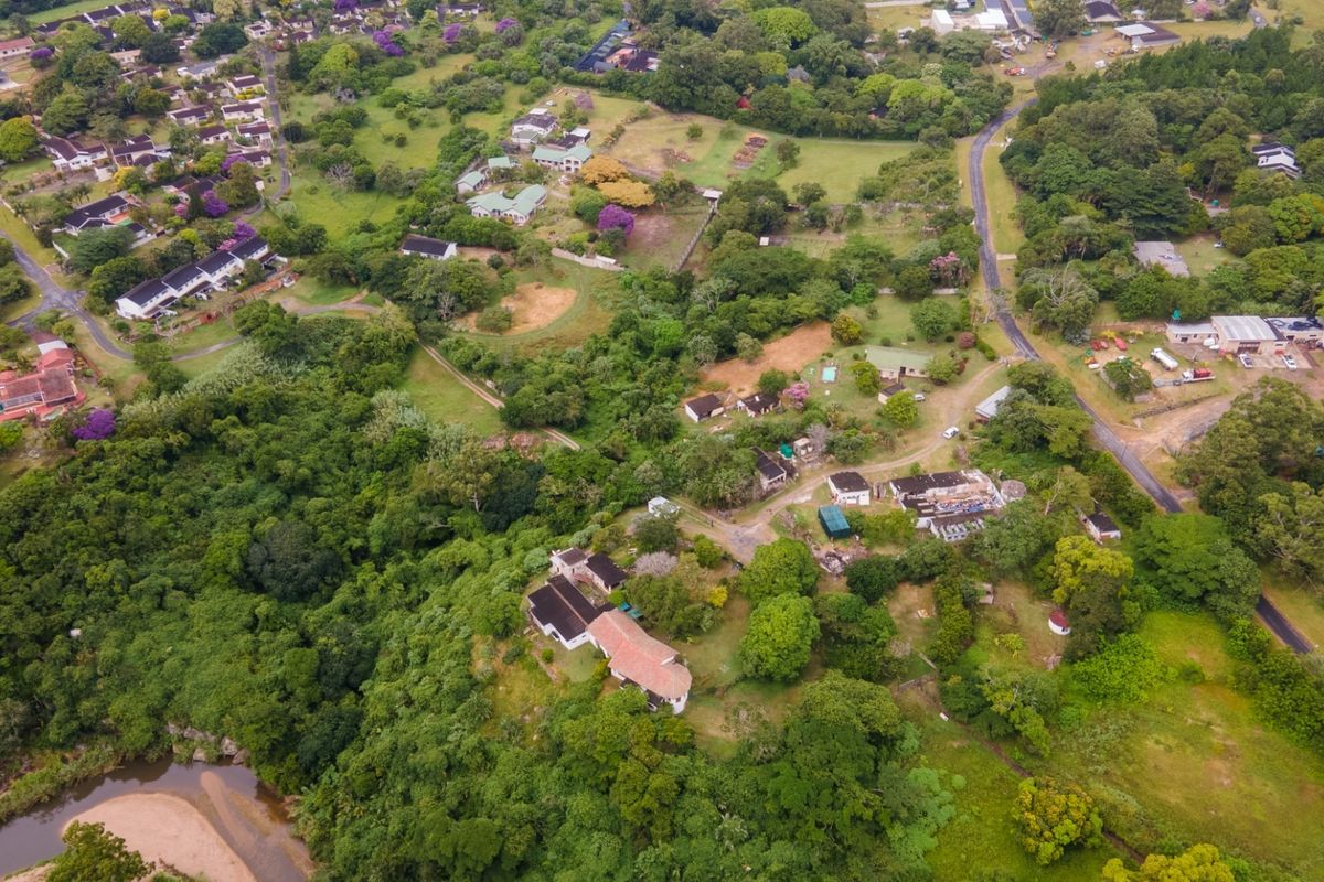 An aerial view of the commercial property grounds, showcasing the surrounding landscape, access roads, and proximity to the river.