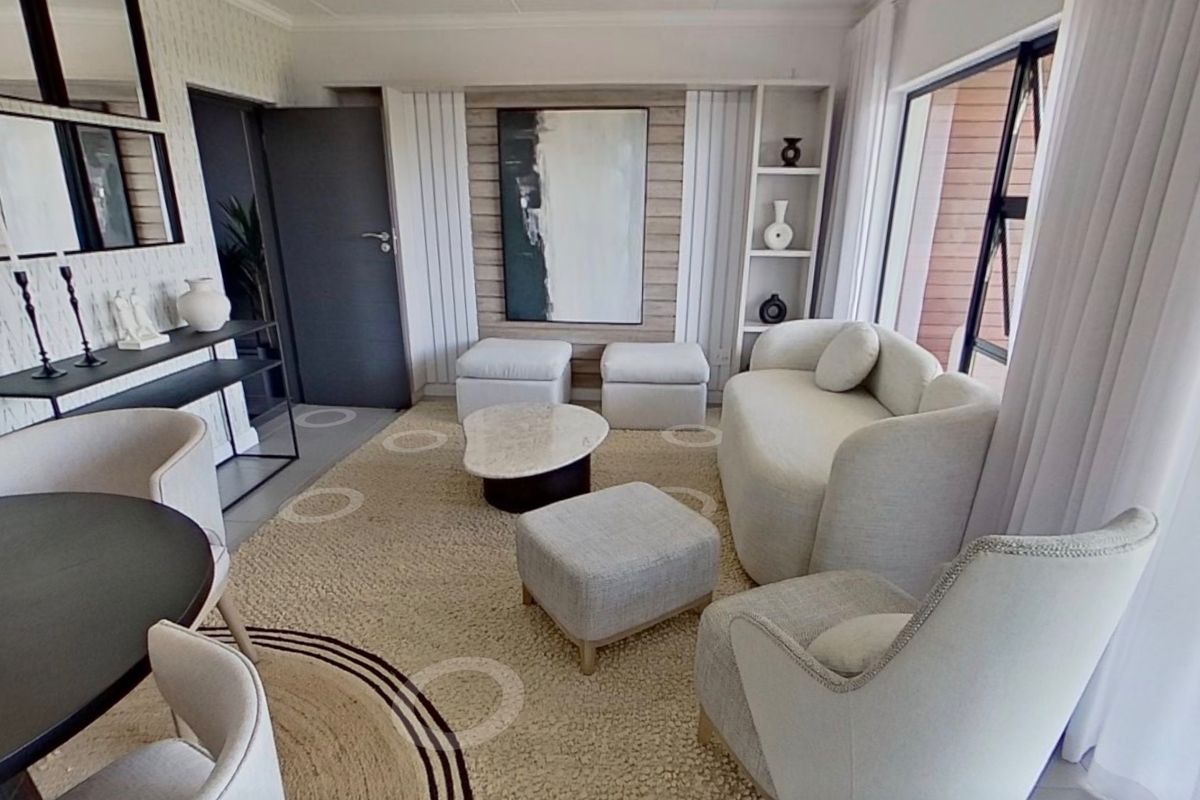 A bright and modern living room featuring built-in shelving, timber wall paneling, and large sliding glass doors that provide ample natural light.