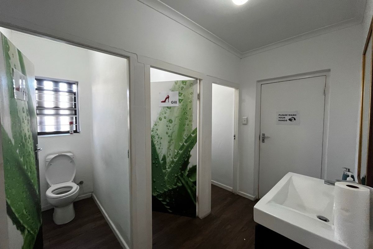 Functional industrial restroom facility featuring multiple toilet cubicles, a vanity basin, and durable flooring, suitable for staff or visitor use.
