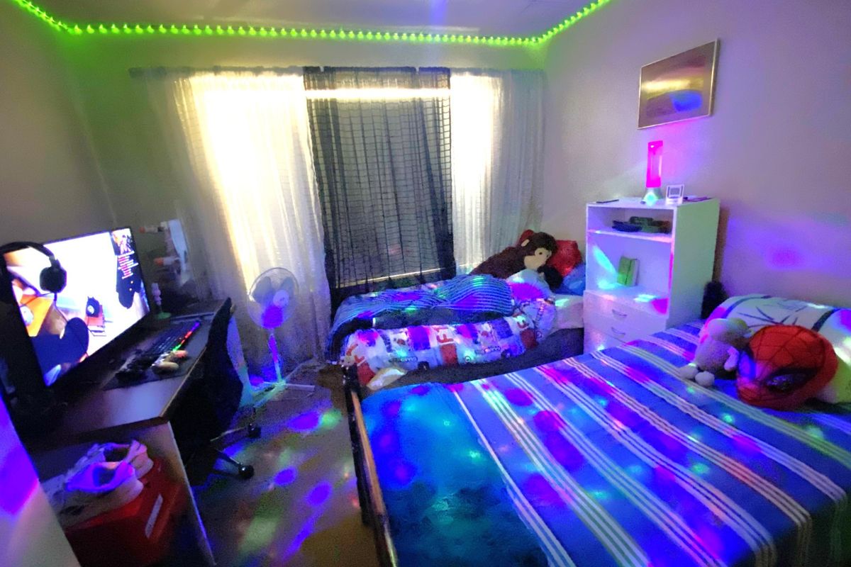 A bedroom featuring a window with curtains, suitable for use as a sleeping or study area.