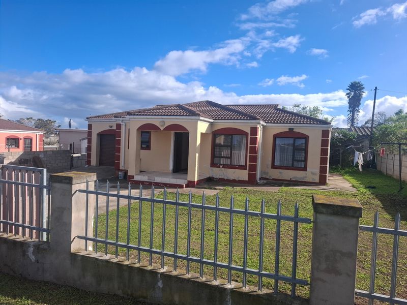 Front elevation of a single-story detached house featuring a tiled roof, metal perimeter fencing, and a single garage with visible exterior maintenance required.