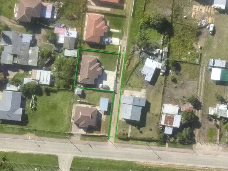 Aerial view of the residential property showing the house footprint, driveway access, and surrounding garden area.
