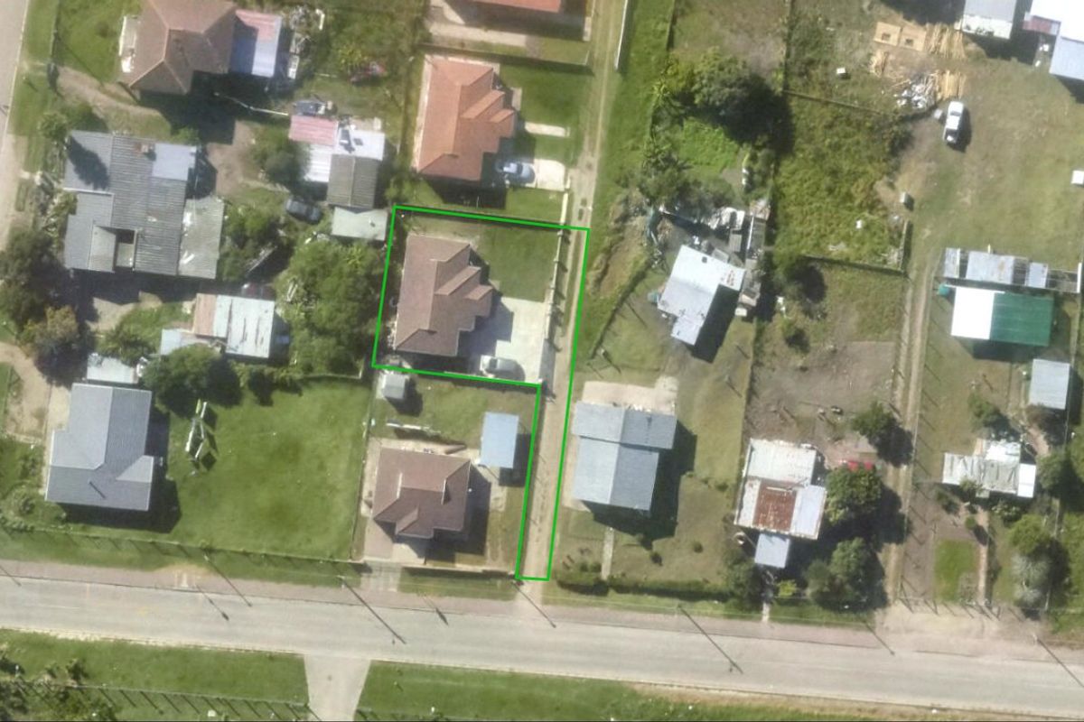 Aerial view of the residential property showing the house footprint, driveway access, and surrounding garden area.