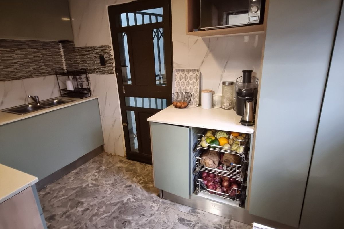 Modern kitchen featuring sleek cabinetry, stone countertops, a double sink, and a built-in microwave, providing a functional and contemporary culinary space.