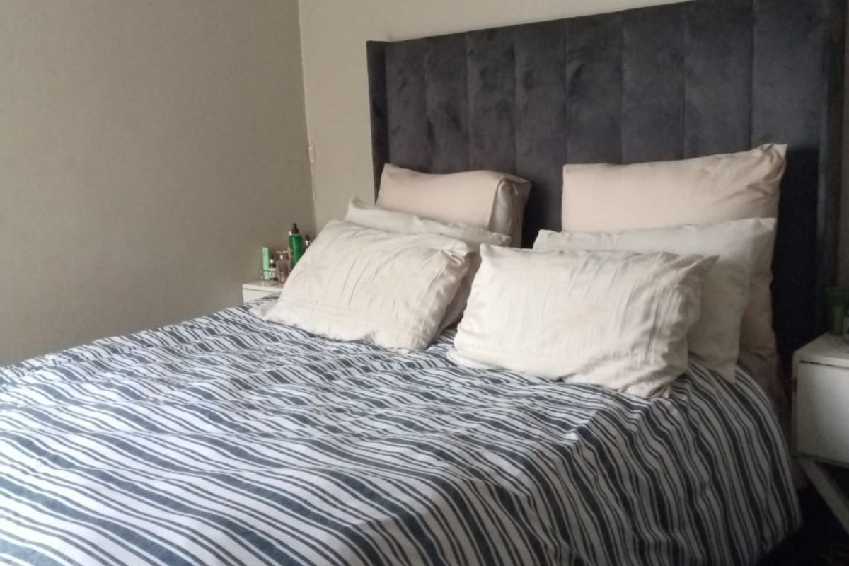 A comfortable bedroom featuring neutral wall tones and decorative crown molding.