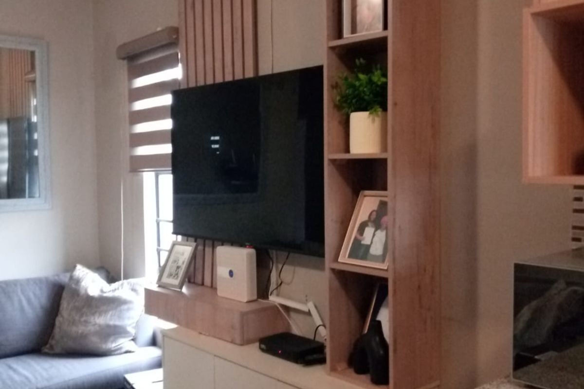 A cozy living area featuring custom built-in shelving, decorative slatted wood wall paneling, and a granite countertop surface.