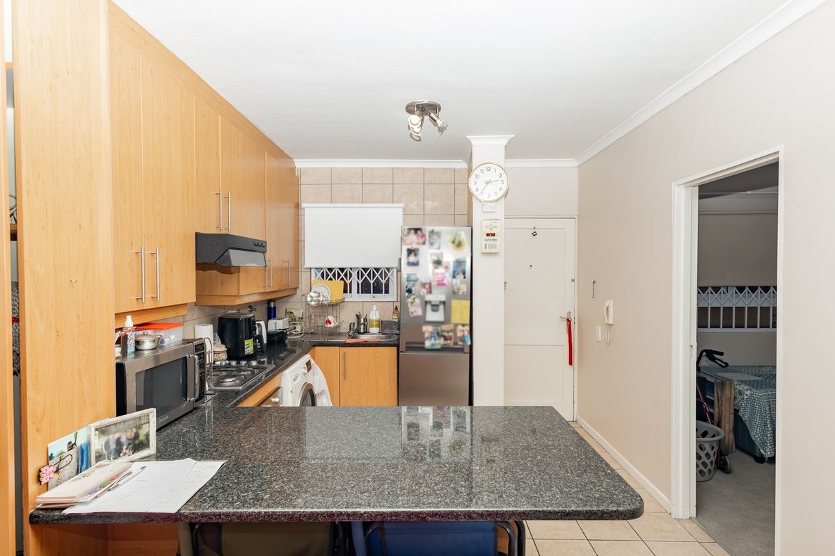A functional kitchen featuring light wood cabinetry, granite countertops, and a breakfast bar, providing a practical layout for daily meal preparation.
