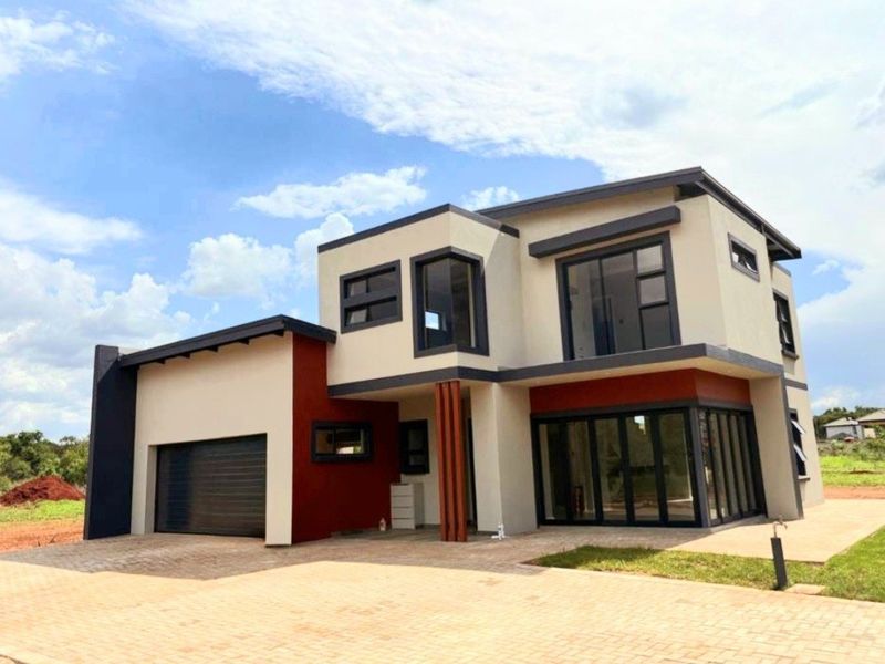 Modern double-storey residential property featuring a contemporary facade, paved driveway, integrated double garage, and large aluminium-framed windows and sliding doors.