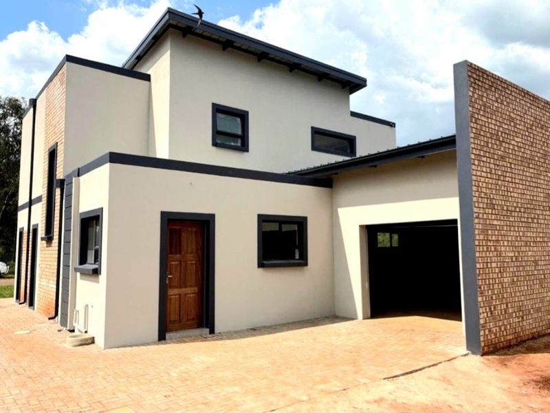 Modern double-storey residential property featuring a contemporary facade, brick accents, paved driveway, and an integrated garage.