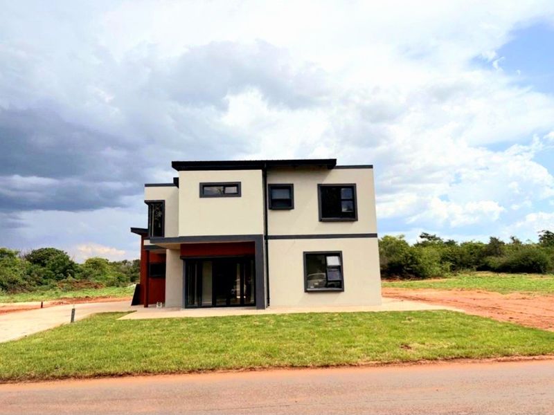 A modern two-story residential property featuring a clean architectural design, dark-framed windows, and a paved driveway set within a landscaped plot.