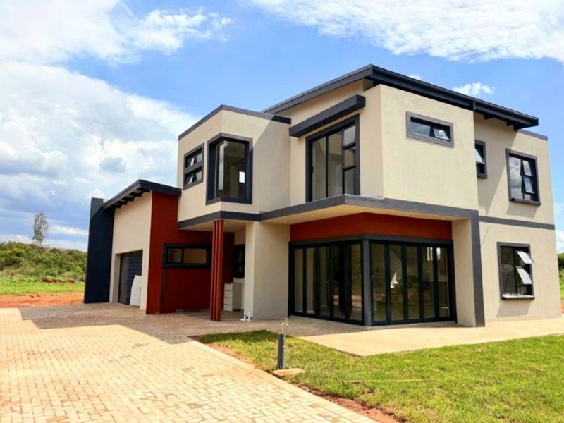 Modern double-storey residential home featuring contemporary architectural design, large aluminium stacking doors, paved driveway, and a clean, well-maintained exterior facade.