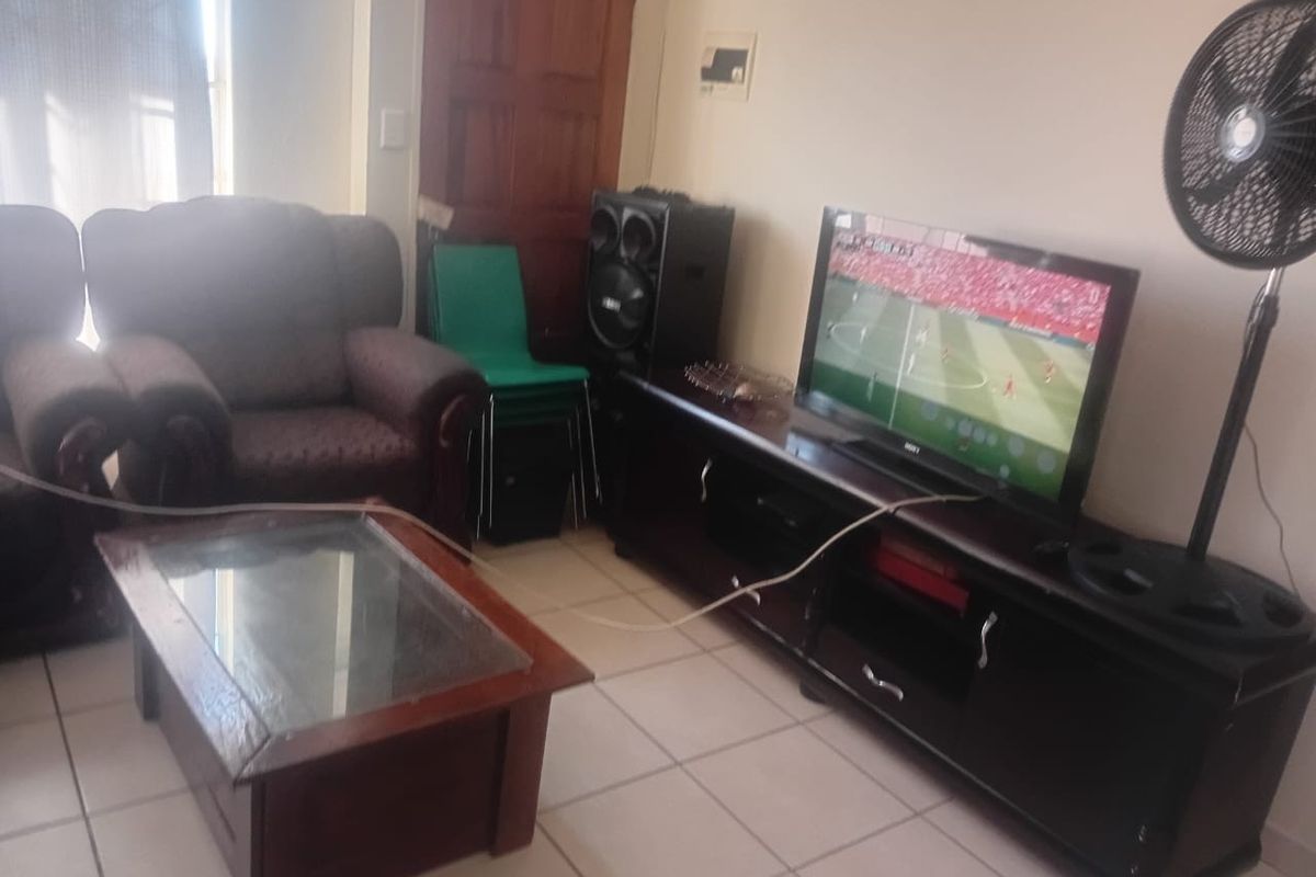 A living room area featuring tiled flooring and a standard layout, suitable for a comfortable family lounge space.