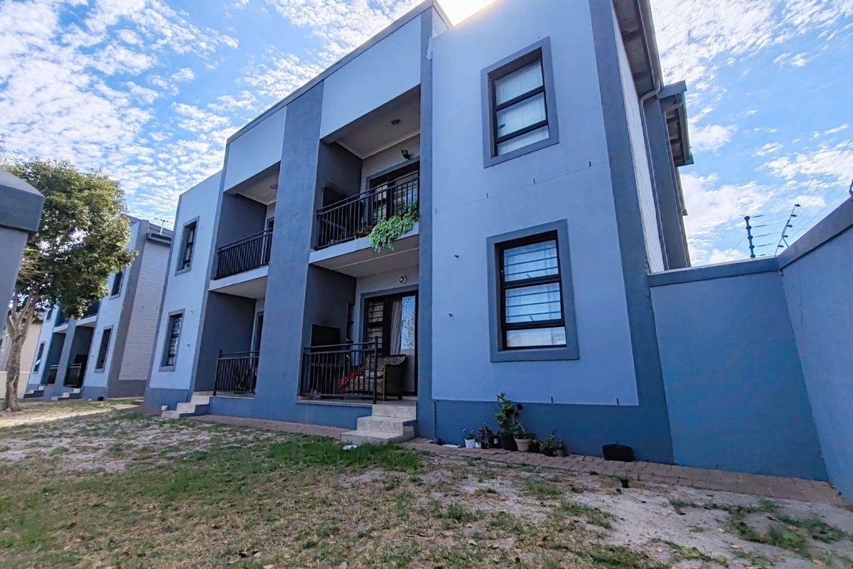 Exterior view of a multi-story apartment building featuring private balconies with metal railings and modern blue-toned facade finishes.