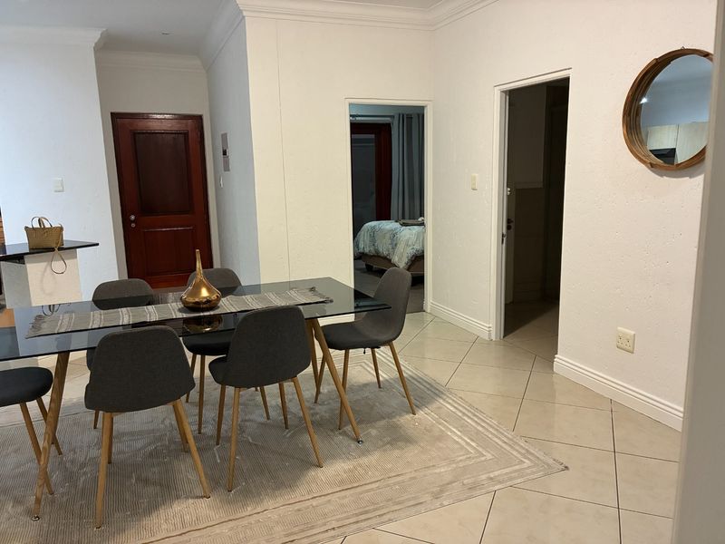 A dining area featuring tiled flooring, crown molding, and access to adjacent rooms through standard doorways.