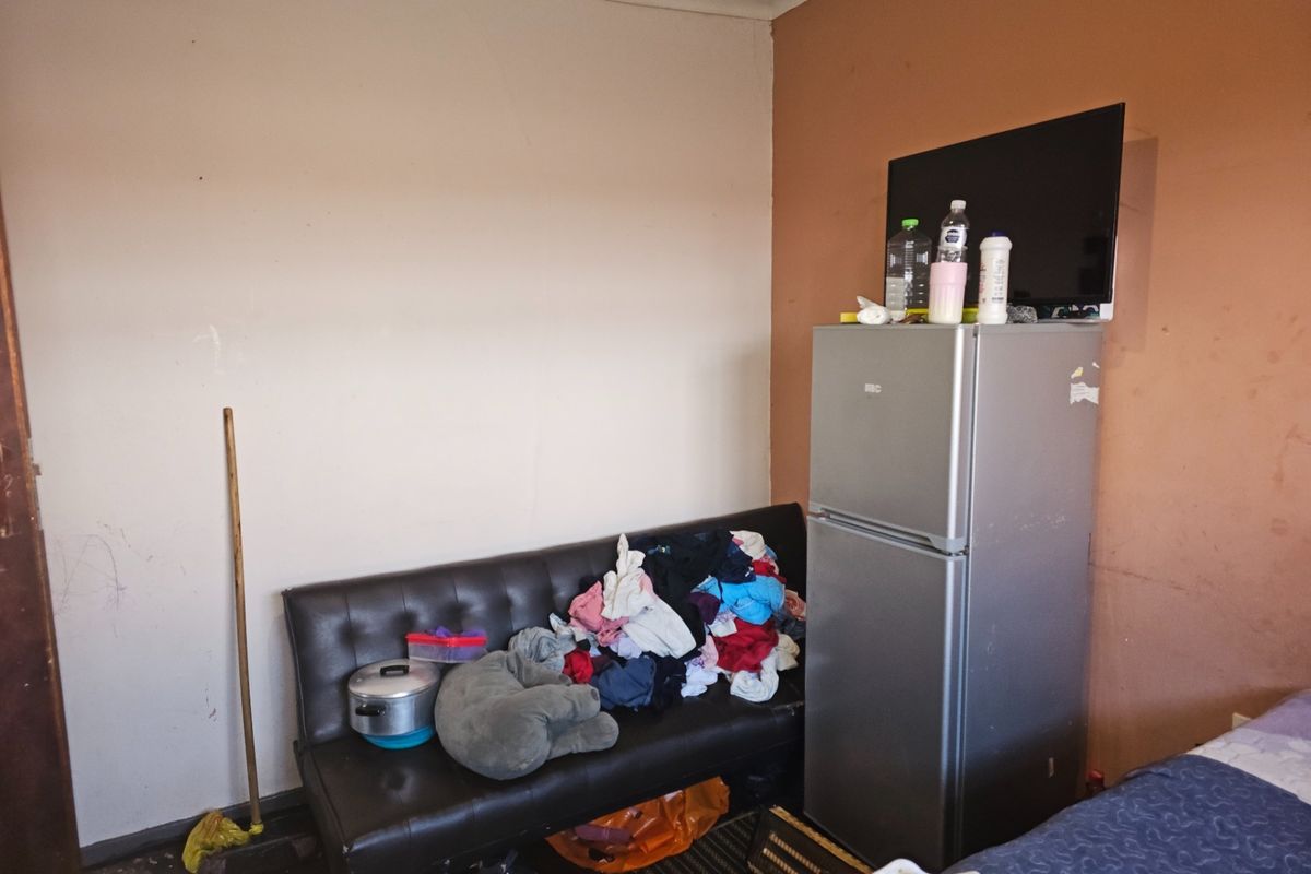 A living area featuring painted walls and basic interior finishes, currently used for storage and living space.