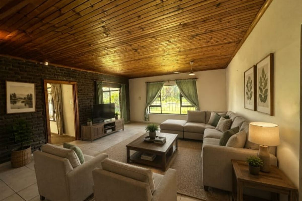 Spacious living room featuring a distinctive exposed dark brick feature wall and a warm timber-clad vaulted ceiling, creating a cozy and inviting atmosphere.