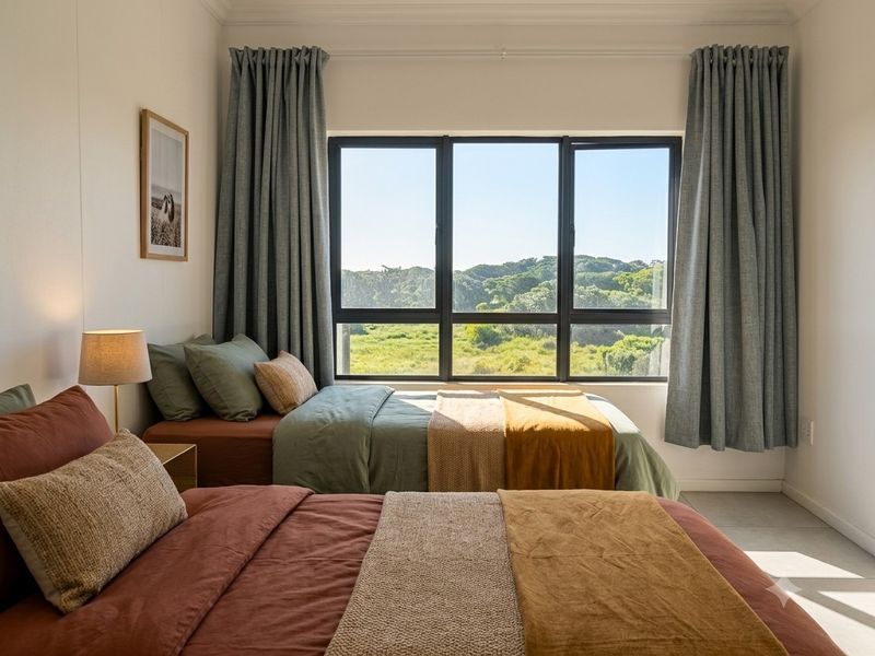 A bright and well-maintained bedroom featuring large windows with natural views, neutral wall finishes, and tiled flooring.