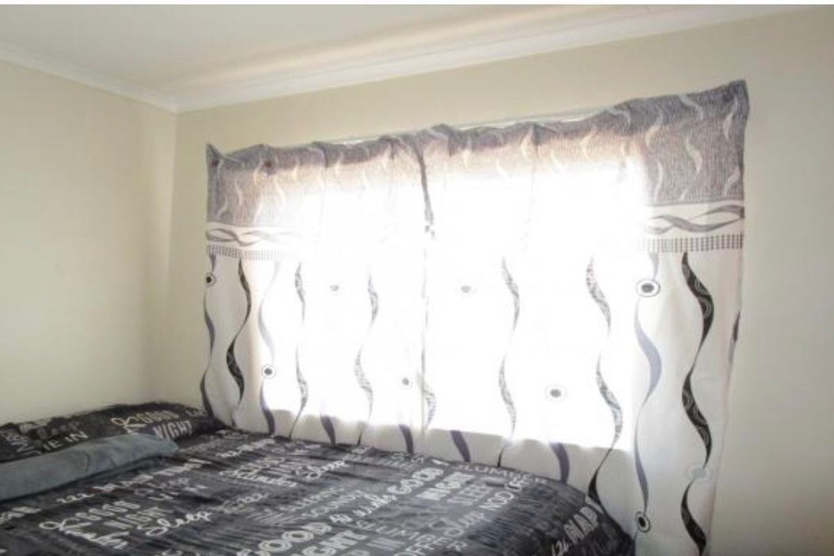 A standard bedroom featuring neutral wall finishes and decorative ceiling cornicing.