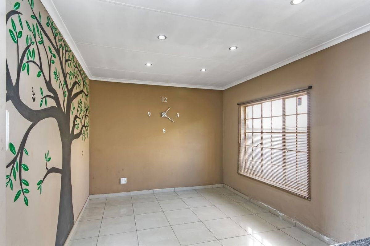 An empty living area featuring tiled flooring, recessed downlighting, and a decorative wall mural, ready for personalization.