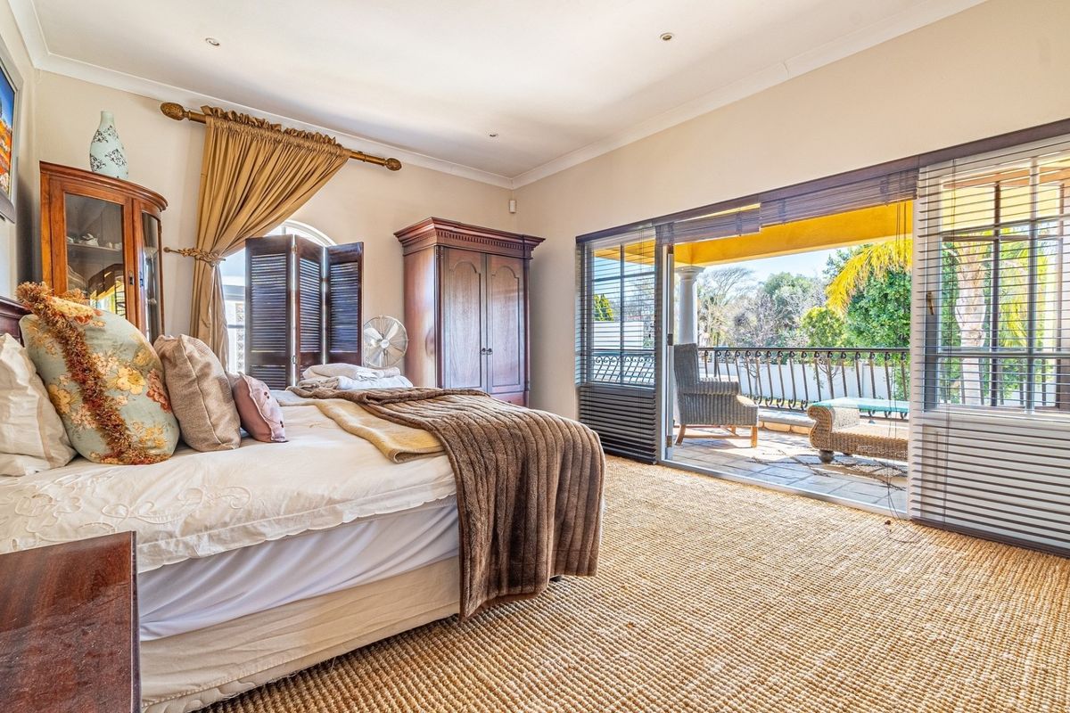 Spacious bedroom featuring large sliding glass doors that open onto a private balcony, providing natural light and outdoor access.