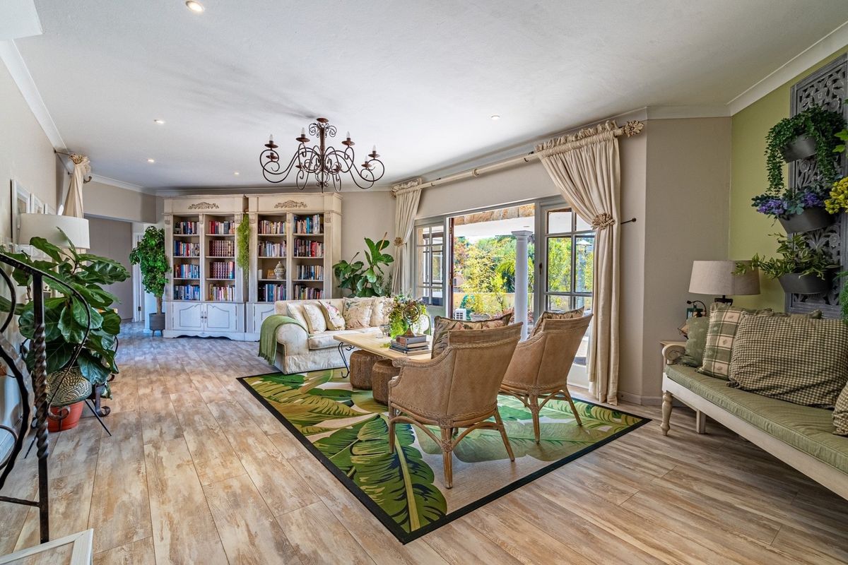 Spacious living room featuring wood-look flooring, built-in cabinetry, and large glass doors opening to an outdoor patio area.