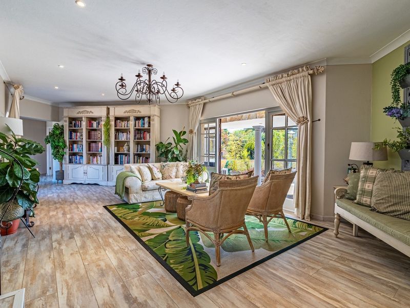 Spacious living room featuring wood-look flooring, built-in cabinetry, and large glass doors opening to an outdoor patio area.