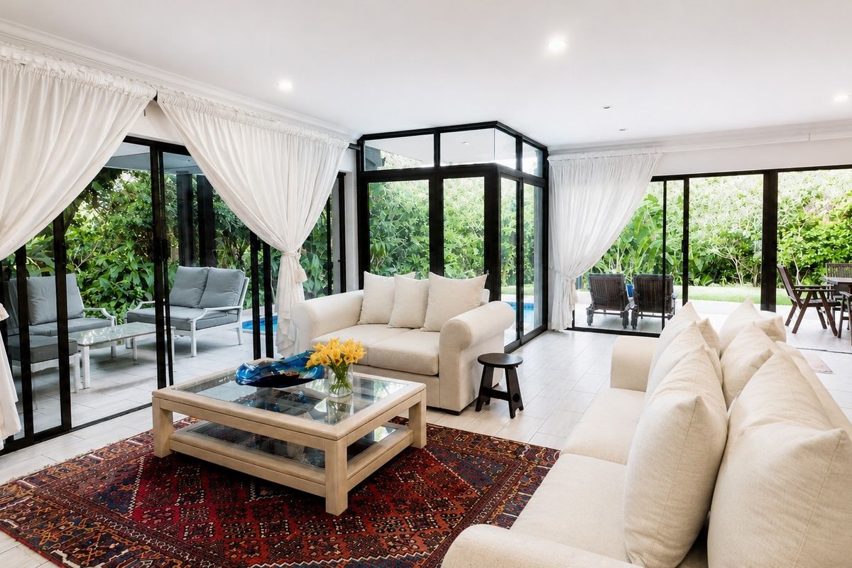 Bright and airy living room featuring large glass sliding doors that provide seamless indoor-outdoor flow to the patio and garden area.
