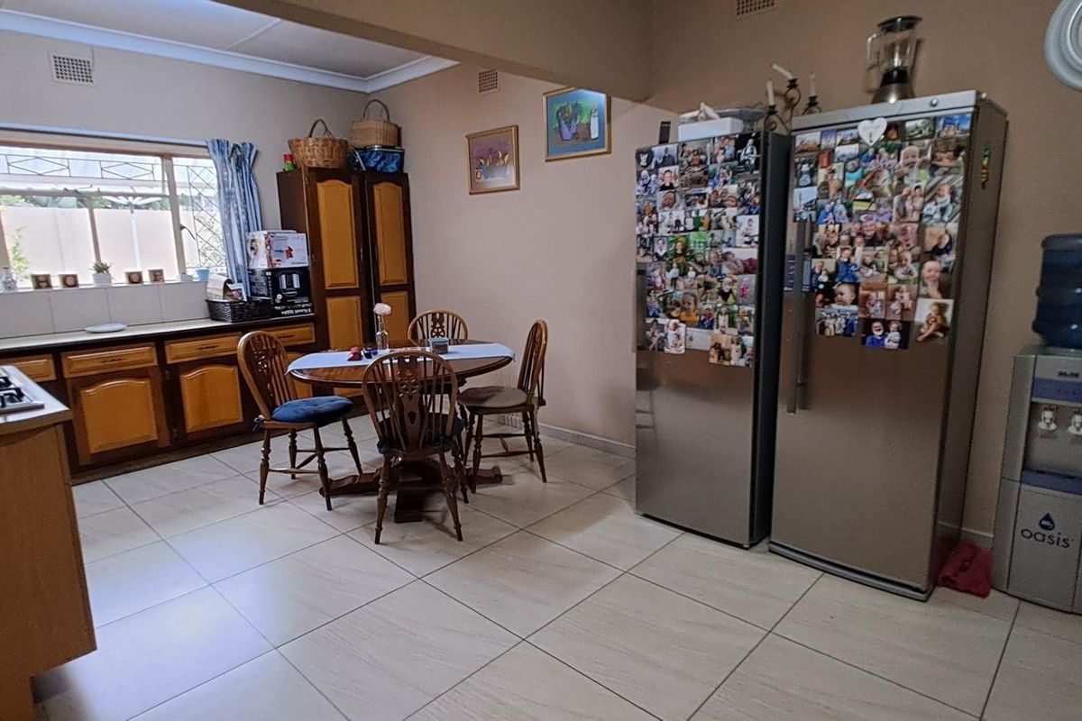 A functional kitchen featuring tiled flooring, built-in wooden cabinetry, and a gas hob, offering a practical layout for daily meal preparation.
